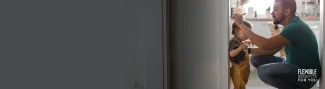 A dad marks his toddler's height on a doorway frame.
